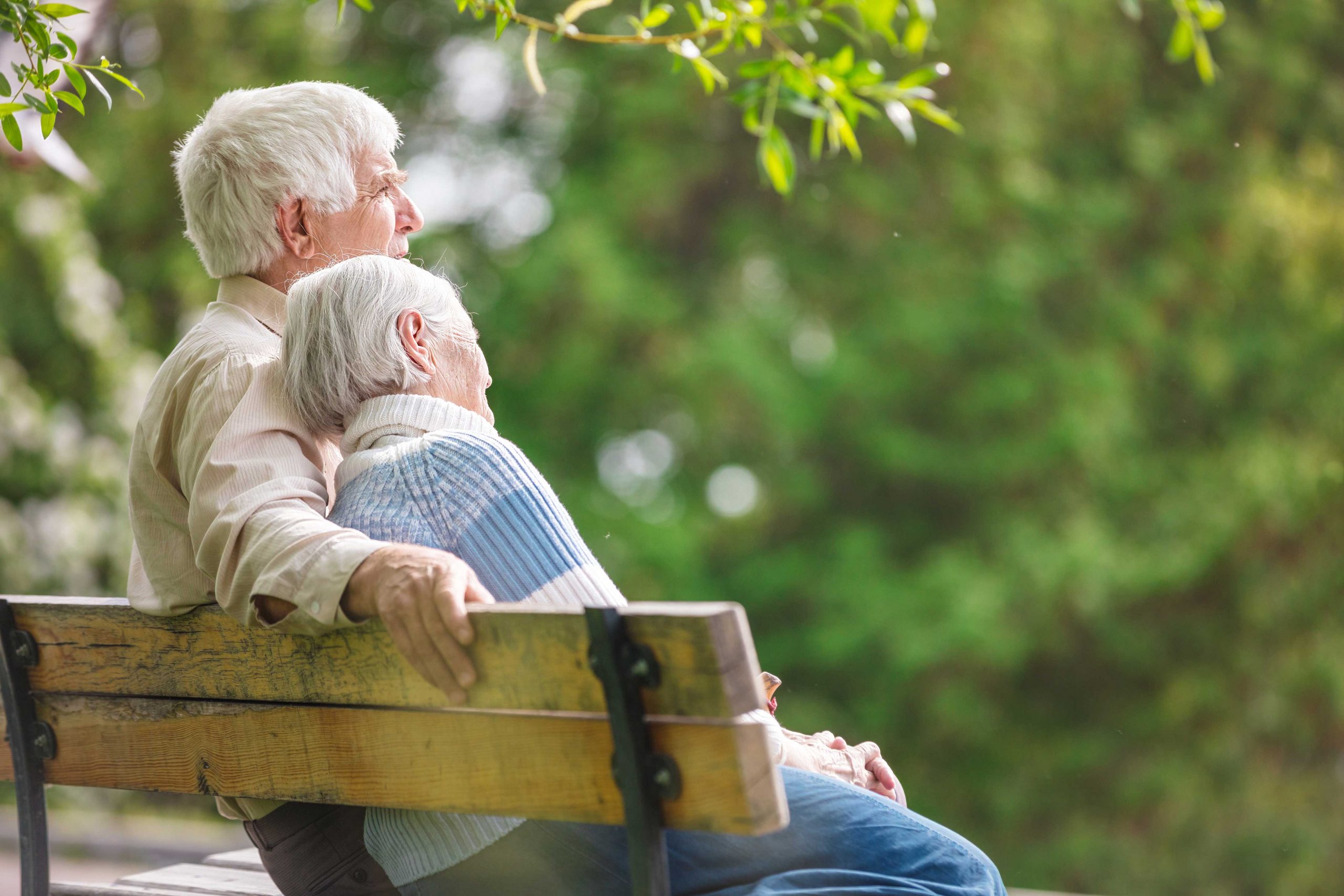 Senior couple sitting together on bench outside