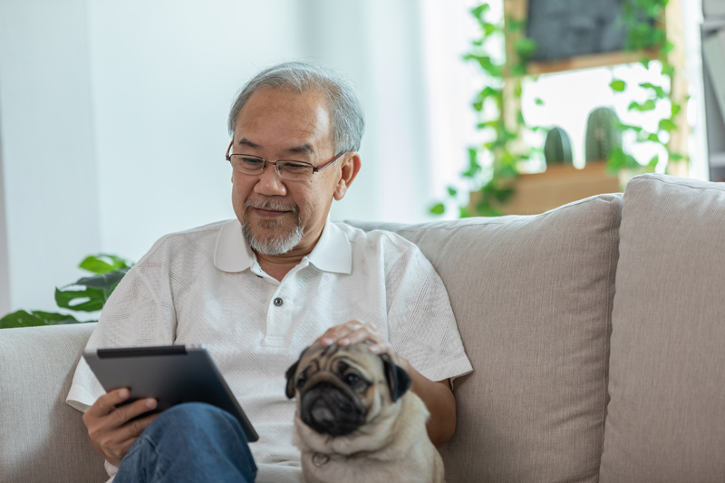 Senior on iPad tablet with dog at VRS retirement home in Nanaimo